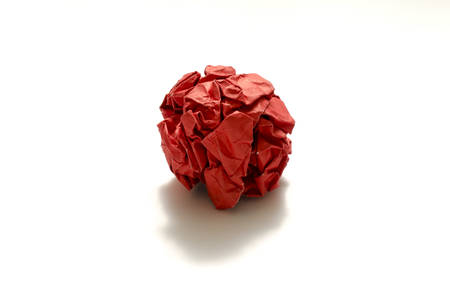 red crumpled paper ball on a white backgroundの写真素材
