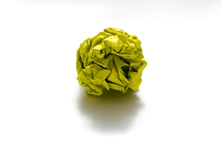 yellow color crumpled paper ball on a white backgroundの写真素材