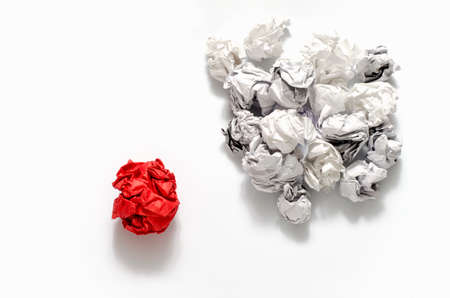 white crumpled paper ball and different red crumpled paper ball on a white backgroundの写真素材
