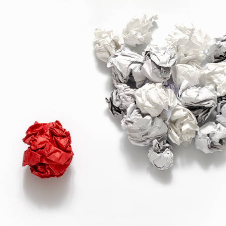 white crumpled paper ball and different red crumpled paper ball on a white backgroundの写真素材