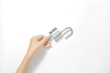 woman hand open padlock with key on a white backgroundの写真素材