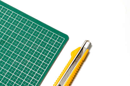 cutter knife on cutting board on a white の写真素材