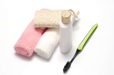 towel loofah liquid soap and toothbrush on a white backgroundの写真素材