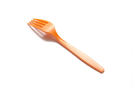 orange plastic fork on a white backgroundの写真素材