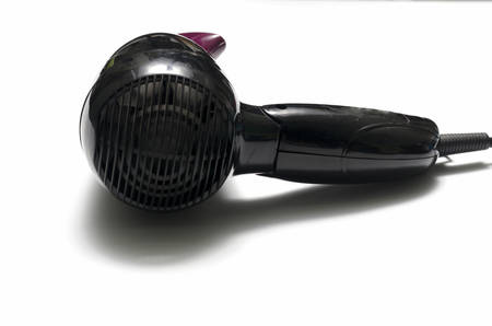 old used electric hair dryer on a white backgroundの写真素材