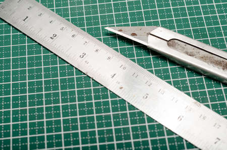 ruler and cutter on green cutting matの写真素材