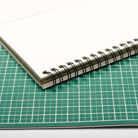 notebook and cutting mat on a white backgroundの写真素材