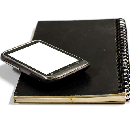 smartphone on note book on a white backgroundの写真素材