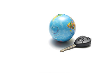 car key and earth ball isolated on white background concept drive around the worldの写真素材