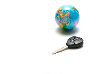 car key and earth ball isolated on white background concept drive around the worldの写真素材