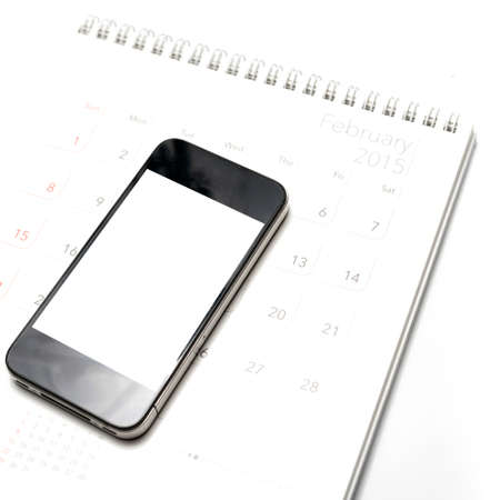 smart phone on calendar isolated on white backgroundの写真素材
