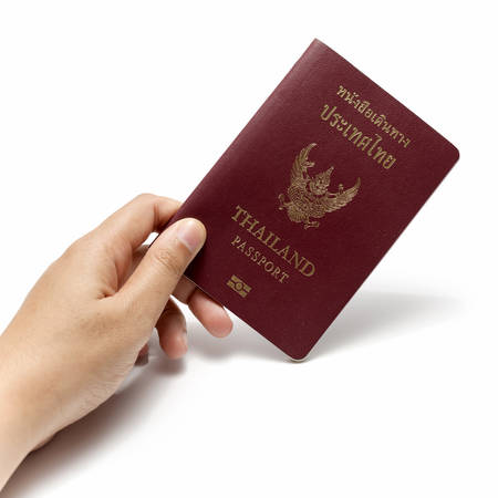 hand holding a passport isolated on white backgroundの写真素材
