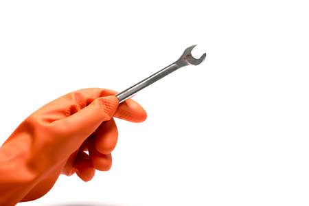 hand in orange glove holding wrench isolated on white backgroundの写真素材