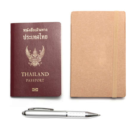 passport with notebook and pen isolated on white backgroundの写真素材