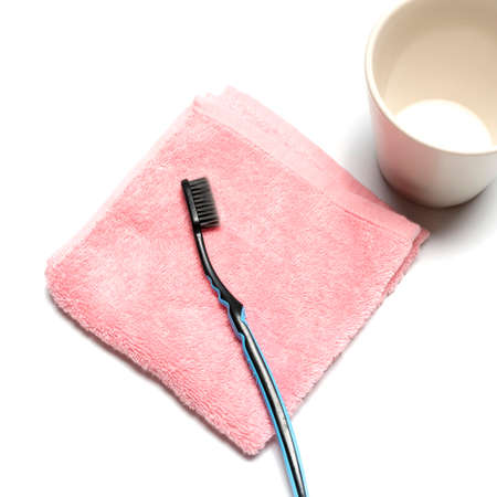 tooth brush and towel with mug isolated on white backgroundの写真素材
