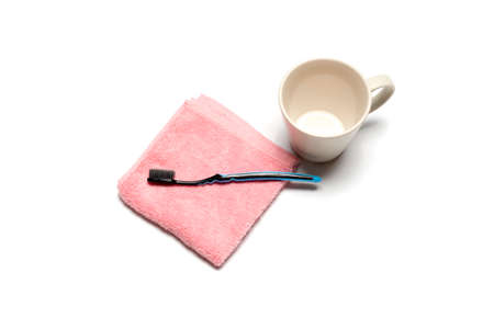 tooth brush and towel with mug isolated on white backgroundの写真素材