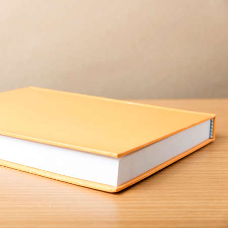 orange book on wood table background