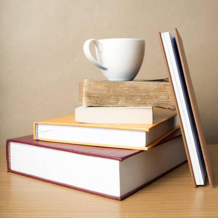 stack of book with coffee cup on wood table backgroundの写真素材