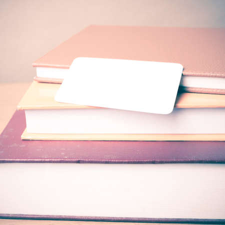 stack of book and business card on wood background vintage style