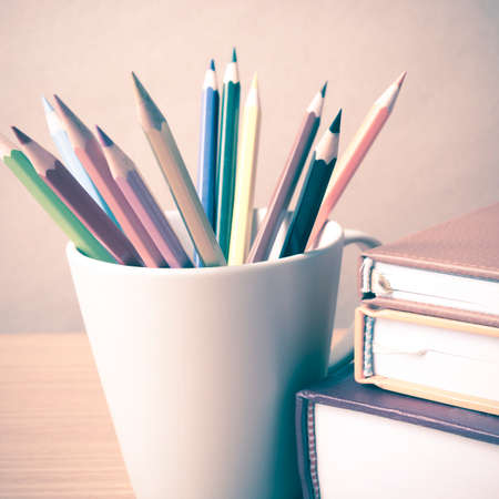 stack of book with color pencil on wood table background vintage styleの写真素材