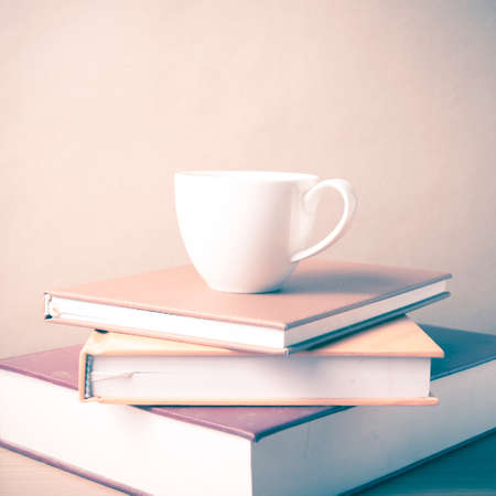stack of book with coffee cup on wood table background vintage styleの写真素材