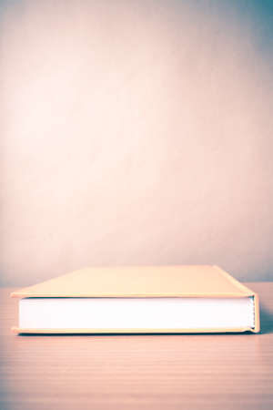 orange book on wood table background vintage styleの写真素材