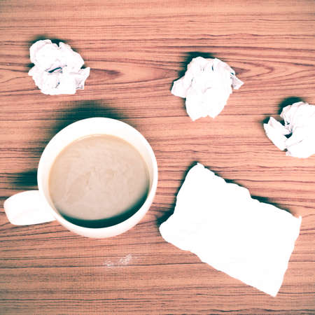 coffe cup and crumpled for idea on wood background vintage style