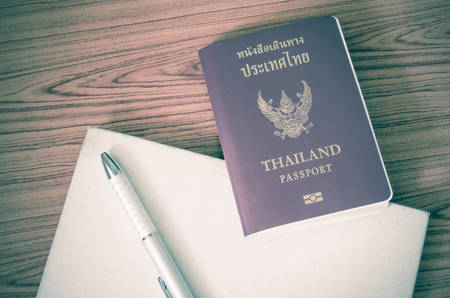 thai passport with notebook on wood table background vintage styleの写真素材