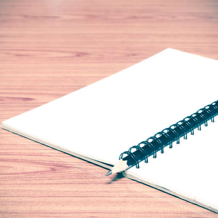 notebook and pencil on wood background vintage style