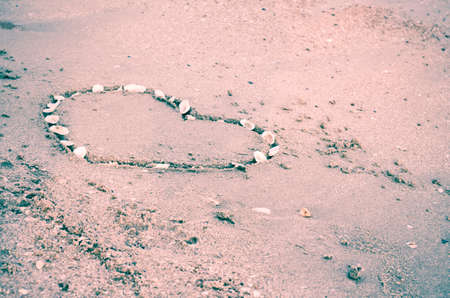 drawing heart on the sand in the beach vintage style