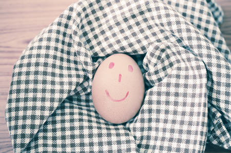 smile love egg couple in brown kitchen towel on wood table vintage styleの写真素材