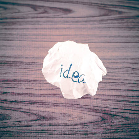 writing idea word on crumpled on wood backgroundの写真素材