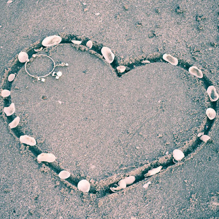 drawing heart on the sand in the beach vintage styleの写真素材