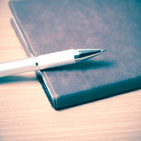 book and pen on wood background vintage styleの写真素材