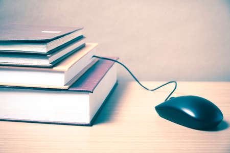 book and computer mouse on wood background vintage styleの写真素材