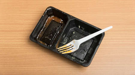 dirty plastic food container on wood background