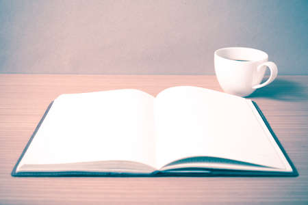 open book with coffee cup on wood background vintage style