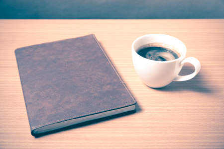 brown book with black coffee on wood background vintage style