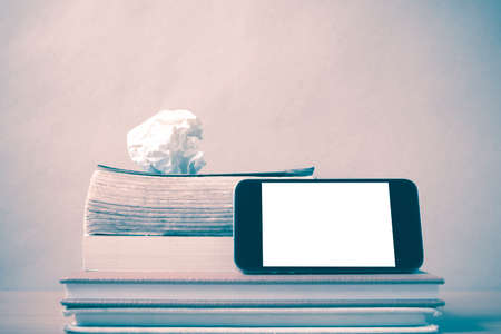 stack of book and smart phone on wood background vintage styleの写真素材