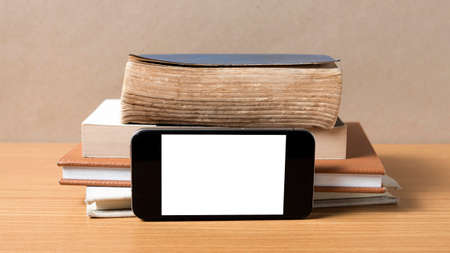 stack of book and smart phone on wood backgroundの写真素材