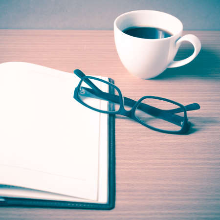 open book with coffee cup on wood background vintage style
