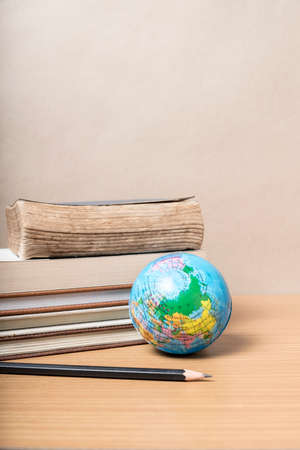 book and earth ball with black pencil on wood backgroundの写真素材