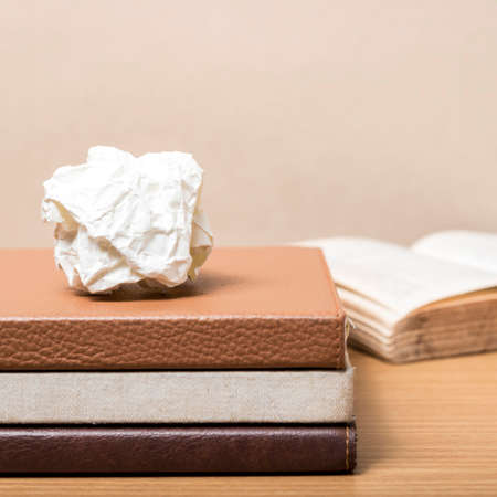 book and crumpled paper on wood backgroundの写真素材