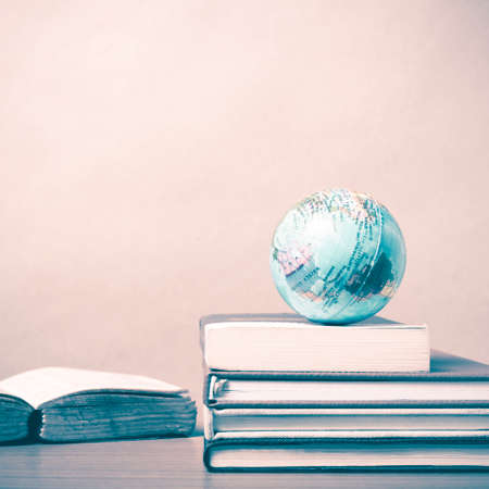 book and earth ball on wood background vintage styleの写真素材