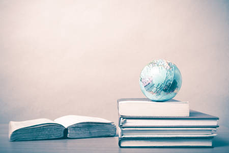 book and earth ball on wood background vintage styleの写真素材