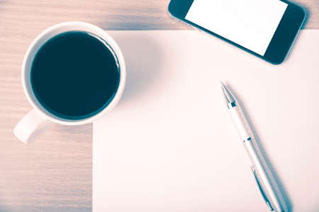 paper and pen with coffee cup and smart phone on wood background vintage styleの写真素材