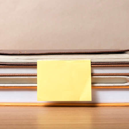 stack of book with sticky note on wood backgroundの写真素材