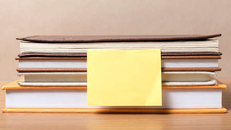 stack of book with sticky note on wood backgroundの写真素材