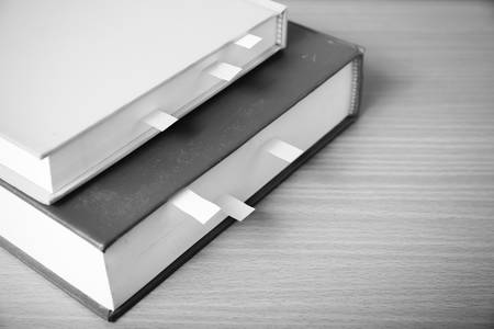 book with sticky note on wood background black and white color tone styleの写真素材