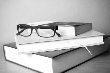 book and eyeglasses on wood background black and white color tone style